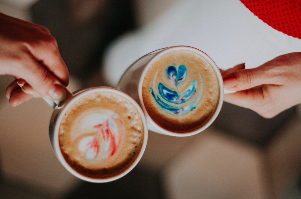 2 coffee cups with red and blue coffee cream designs.